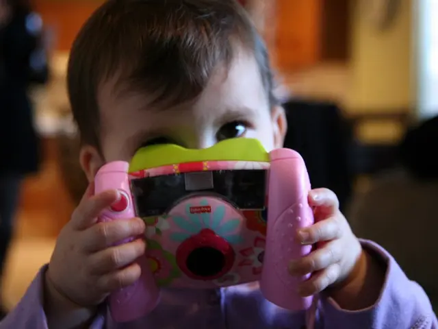 In this picture we can see a kid is holding a toy in hands.