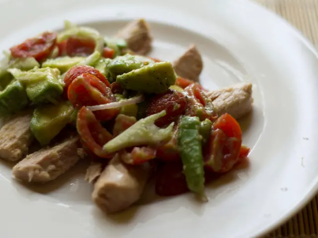 In this image I see the food white plate on which there is food which is of green, brown and red in...