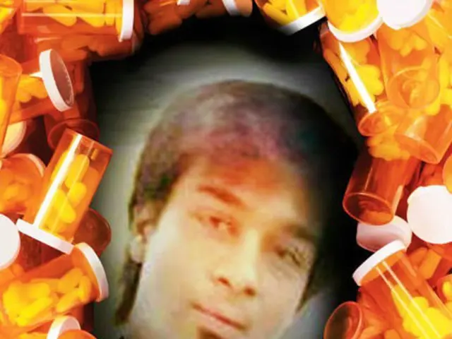 In this image I can see the person's photo. To the side of the photo I can see many bottles and few...