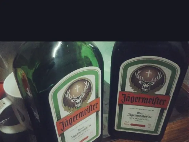 There are two bottles and cup on the table.